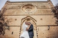 Fashionable wedding couple near Catholic church. Bride and Groom. Outdoor portrait