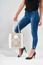 Fashionable white bag on the woman s legs background