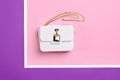 Fashionable white leather women\'s handbag with gold shoulder chain and stylish metal clasp on a multi-colored background Royalty Free Stock Photo