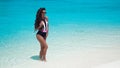 Fashionable Woman in bikini suntanning on tropical beach. Pretty slim girl posing on exotic island by beautiful turquoise ocean. Royalty Free Stock Photo