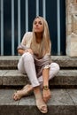 Woman sitting stairs medieval Romanesque door evening sun Royalty Free Stock Photo