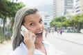 Fashionable woman with blonde hair at phone in the city Royalty Free Stock Photo