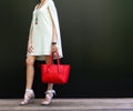 Fashionable woman with long beautiful legs in Ribbon Tie Stilleto shoes standing on the black background. Girl holding a