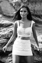 Fashionable woman posing on a beach with rocks in dress Royalty Free Stock Photo