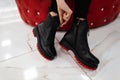 Fashionable woman sits in a store and measures autumn shoes.Close-up of female legs in stylish jeans in trendy leather black boots Royalty Free Stock Photo