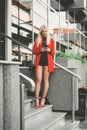 Fashionable woman stading on stairs and using mobile phone Royalty Free Stock Photo