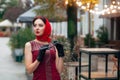 A fashionable woman with sunglasses, in a red dress, leather gloves, tights, red shoes and a scarf Royalty Free Stock Photo