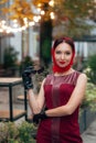 A fashionable woman with sunglasses, in a red dress, leather gloves, tights, red shoes and a scarf Royalty Free Stock Photo