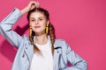 fashionable woman with yellow pigtail earrings posing pink background Royalty Free Stock Photo