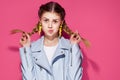 fashionable woman with yellow pigtail earrings posing pink background Royalty Free Stock Photo
