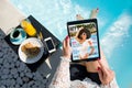 Woman relaxing by the pool and reading emagazine on tablet at breakfast. All contents are made up. Royalty Free Stock Photo