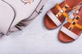 Fashionable women`s sandals and backpack on white wooden background Royalty Free Stock Photo