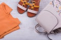 Fashionable women`s sandals and backpack on white wooden background Royalty Free Stock Photo