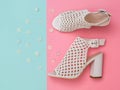Fashionable women`s white summer shoes with flowers on turquoise and pink background. Flat lay. Royalty Free Stock Photo