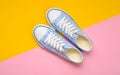 Fashionable women& x27;s sneakers with white laces from the 80s on a yellow pink pastel background. Top view. Royalty Free Stock Photo