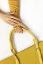 Fashionable yellow on the bag and manicure.