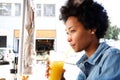 Fashionable young african woman sipping orange juice