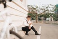 Fashionable young bearded man using a digital tablet , cheerfully smiling, watching or reading something funny, sitting on the Royalty Free Stock Photo