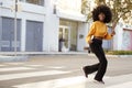 Fashionable young African American woman with afro hair running across the street, full length, close up Royalty Free Stock Photo