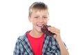 Fashionable young boy eating chocolate cookie Royalty Free Stock Photo