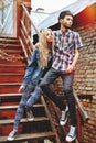 Fashionable young couple standing on stairs and hugging each other Royalty Free Stock Photo