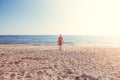 Alone girl walking along a deserted beach at sunset Royalty Free Stock Photo