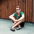 Fashionable young guy with sunglasses in a shirt and shorts Royalty Free Stock Photo