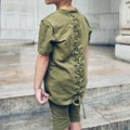 Fashionable young kid wearing green t-shirt and summer shorts. Kids street fashion summer clothes.