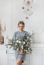 Fashionable young leggy woman with platinum blond hair in knitted dress posing with Christmas decorations. Model girl Royalty Free Stock Photo