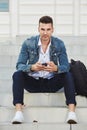 Fashionable young man with phone listening to music Royalty Free Stock Photo