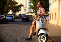 Fashionable young man riding a vintage scooter in street Royalty Free Stock Photo