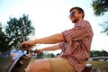 Fashionable young man riding a vintage scooter in street Royalty Free Stock Photo