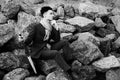 fashionable young man sitting on the rocks near the sea Royalty Free Stock Photo