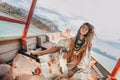 Fashionable young model in boho style dress on boat at the lake Royalty Free Stock Photo