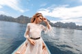Fashionable young model in boho style dress on boat at the lake Royalty Free Stock Photo