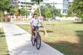 Fashionable young teen girl in shorts and t-shirt rides a bicycle in a summer park Royalty Free Stock Photo