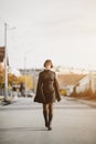 Fashionable young woman in black dress walks down the street, fashion and clothing concept Royalty Free Stock Photo