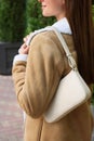 Fashionable young woman with stylish bag on city street, closeup Royalty Free Stock Photo