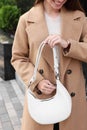 Fashionable young woman with stylish bag on city street, closeup Royalty Free Stock Photo