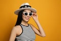 Fashionable young woman in stylish outfit with bandana on orange background Royalty Free Stock Photo