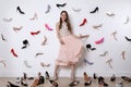Fashionable young woman surrounded by many different high heel shoes indoors Royalty Free Stock Photo