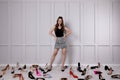 Fashionable young woman surrounded by many different high heel shoes indoors Royalty Free Stock Photo