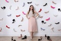 Fashionable young woman surrounded by many different high heel shoes indoors Royalty Free Stock Photo