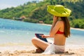 Fashionable young woman talking on mobile phone while on the beach Royalty Free Stock Photo