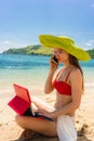 Fashionable young woman talking on mobile phone on the beach Royalty Free Stock Photo