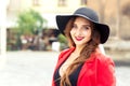 Fashionable young woman is wearing black hat looking at camera outdoors. Royalty Free Stock Photo