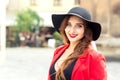 Fashionable young woman is wearing black hat looking at camera outdoors Royalty Free Stock Photo