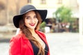 Fashionable young woman is wearing black hat posing outside in a city street Royalty Free Stock Photo