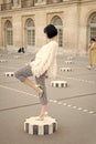 Fashionable young woman in white blouse and high heel shoes on city streets. Fashion in Paris, France