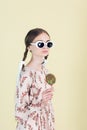 fashionable youth girl in sunglasses with braids holding lollipop